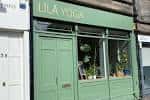 Fachada exterior del estudio Līla Yoga con su rótulo verde