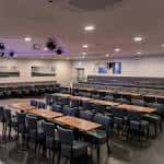 Interior del salón de eventos con mesas y sillas dispuestas para una celebración