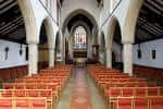 Interior del capilla o iglesia con bancos rojos y arcos góticos