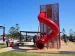 Vista del parque infantil con tobogán rojo en Stockton Active Hub