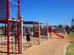 Área de juegos infantiles con estructuras metálicas y toboganes en Stockton Active Hub