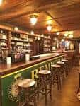 Interior del bar del Club Alpino Tajahierro con barra de madera y taburetes