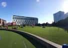 Vista panorámica de Chavasse Park con césped y edificios modernos al fondo