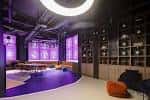 Sala privada o lounge con iluminación púrpura y decoración moderna