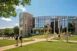 Exterior de Hillman Hall con personas caminando por senderos entre edificios