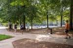 Sendero arbolado dentro del parque con personas caminando y disfrutando del entorno