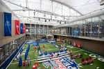 Vista interior del hall principal con campo de fútbol en miniatura y banderas