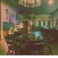 Área de bar o lounge con mesas y decoración elegante