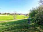 Área verde del parque con sendero y vegetación bajo cielo despejado