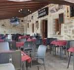 Zona de comedor exterior cubierta con mesas preparadas para eventos