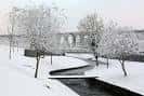 Paseo do Rato cubierto de nieve con puente de ferrocarril