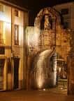 Antigua puerta o arco romano iluminado por la noche en Lugo