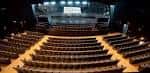 Interior del auditorio con butacas vacías y escenario principal