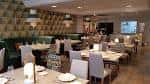 Salón comedor moderno con decoración geométrica y asientos de terciopelo