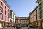 Vista amplia de la Plaza del Fontán rodeada de edificios coloridos bajo el sol.