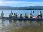 Equipo de remo en un bote dragón en el lago