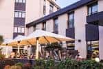 Terraza exterior del hotel con sombrillas y mesas, ideal para eventos al aire libre.
