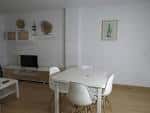 Comedor moderno en apartamento con mesa blanca y sillas de diseño