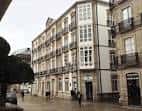 Fachada de la Sede Afundación Lugo en una calle urbana con balcones.