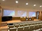 Auditorio de la Casa do Saber con escenario y pantallas de proyección