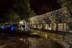 Jardín exterior iluminado por la noche, ideal para eventos