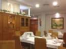 Comedor con mesas preparadas y aparador de madera