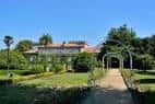 Vista del Pazo Quiñones de León a través de los jardines y un arco vegetal