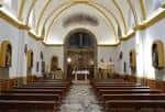 Interior de la nave central del Santuario del Cristo de las Cadenas, mostrando los bancos y el altar