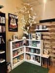 Rincón interior de la librería con estanterías blancas y decoración floral