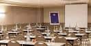 Sala de reuniones configurada en estilo aula con proyector y mesas