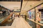 Pasillo principal del Centro Comercial As Termas con tiendas y escaleras mecánicas