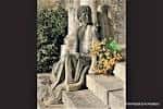 Estatua funeraria o escultura con ofrenda floral en el cementerio de Boisaca