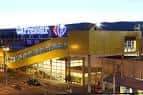 Vista exterior nocturna del Centro Comercial Carrefour Pontevedra con pasarela elevada