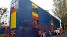 Fachada exterior de un edificio anexo o modular de colores azul, rojo y amarillo