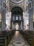 Interior de la Basílica de San Juan el Real, mostrando la nave central, columnas y el camino hacia el altar
