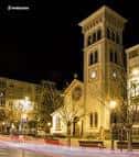Vista nocturna de la Parroquia de la Milagrosa y la plaza circundante iluminada