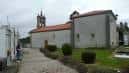 Vista lateral de la Iglesia de Santiago de Requián, mostrando el edificio principal y el entorno exterior