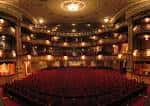 Interior del auditorio principal con butacas rojas y múltiples niveles de palcos