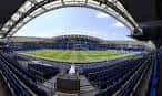 Vista panorámica del interior del estadio, mostrando el campo de juego y las gradas vacías