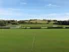 Amplia zona de césped y campo deportivo en East Brighton Park