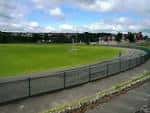 Vista panorámica del campo de césped junto a la pista de ciclismo o carrera en Preston Park