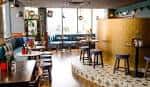 Interior moderno del bar con asientos de banco y mesas altas
