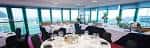 Interior de un palco ejecutivo o sala de eventos con mesas preparadas y grandes ventanales