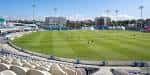 Vista panorámica del campo de cricket y las gradas del estadio bajo el sol