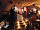Interior de la sala de eventos o función con iluminación cálida y gente socializando
