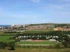 Vista aérea del estadio The Enclosed Ground de Whitehawk FC y el paisaje urbano de Brighton bajo un cielo despejado