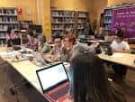 Participantes en un taller o evento sentados en la mesa de trabajo del centro