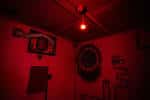 Detalle de la sala 'The Lift Shaft' con iluminación roja intensa y elementos de pared temáticos