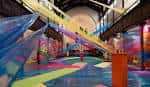 Interior de la nave principal de Fabrica con una instalación de arte contemporáneo colorida