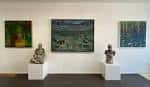 Interior de la galería de arte mostrando una sala de exposición con pinturas y esculturas
